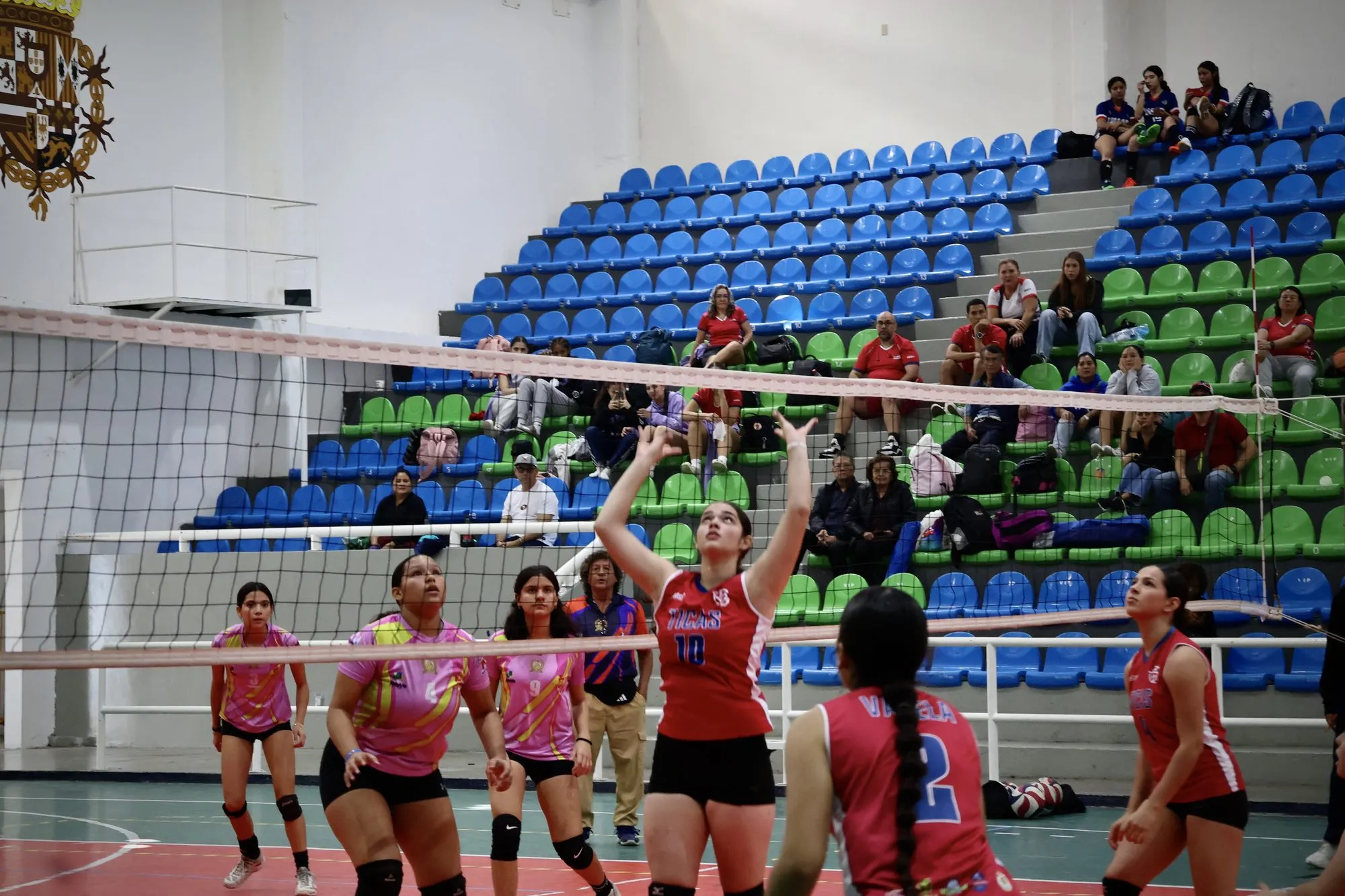 Las jugadoras celebran un punto junto a la red mientras el equipo rival se reorganiza.