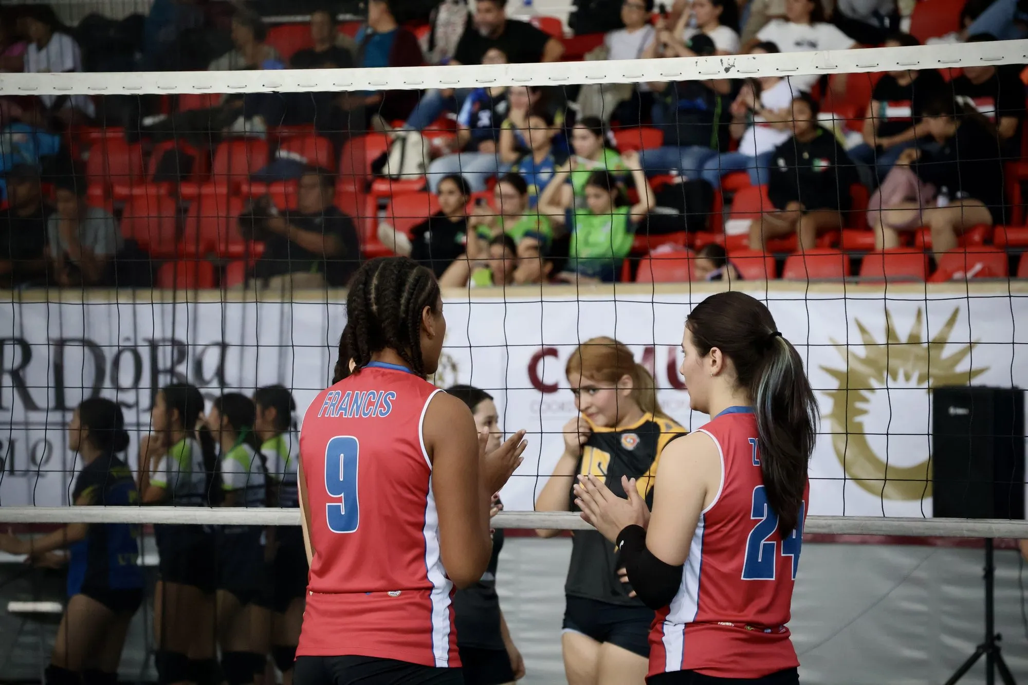 Dos jugadoras conversan junto a la red durante una pausa del partido.