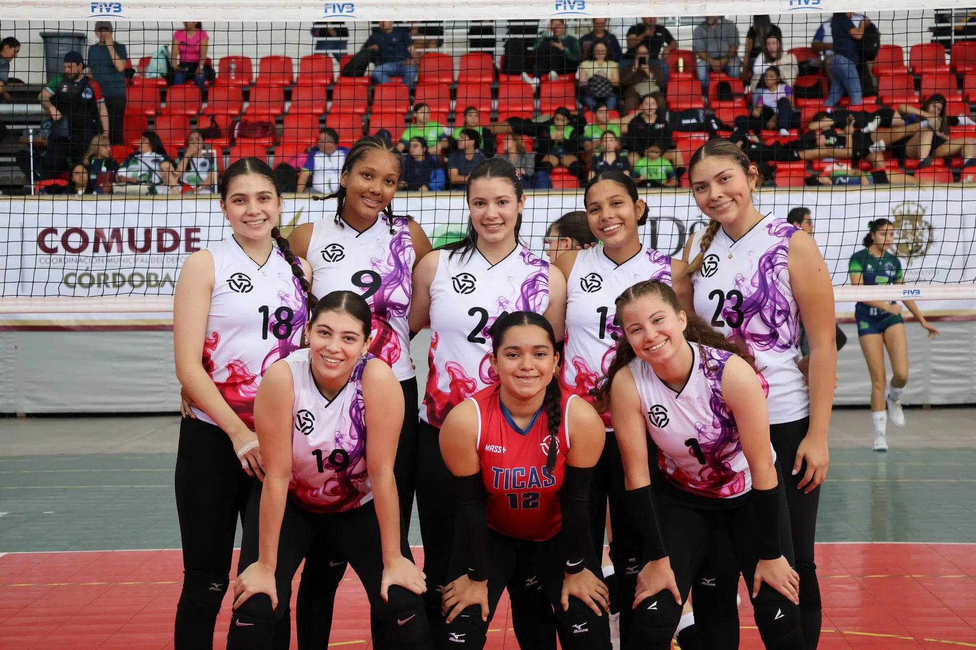 Un equipo posa en la cancha con la camiseta rosada y blanca del torneo.